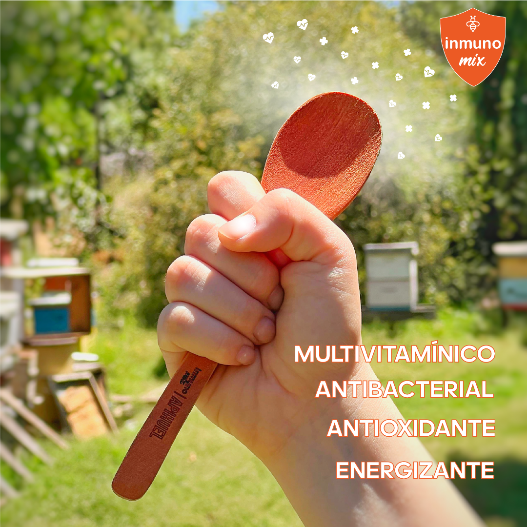 A hand holding a wooden spoon with a logo of a bee, part of Inmuno Mix product line.