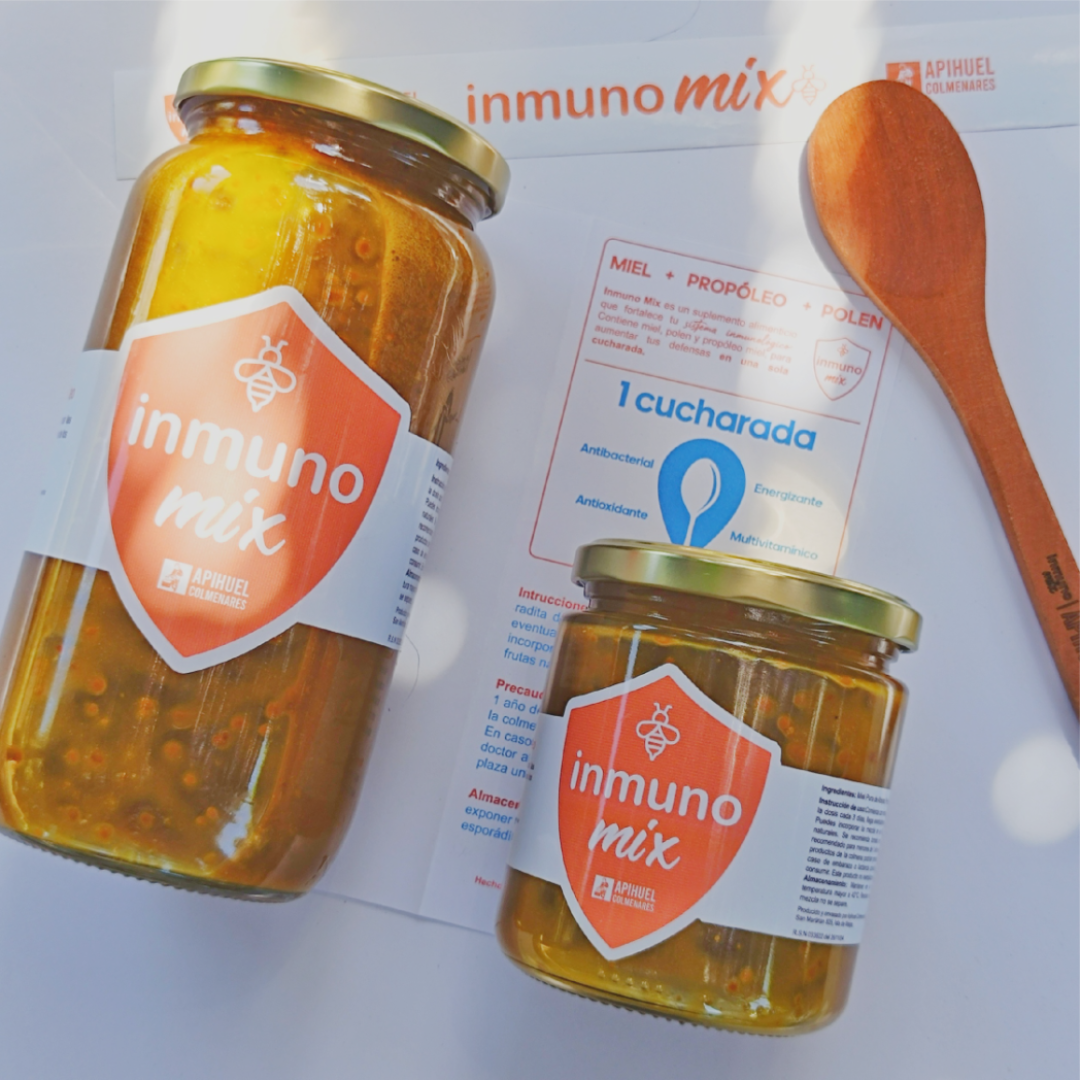Inmuno Mix product image: Two jars of immune-boosting food with labels, a wooden spoon, and a bottle label.